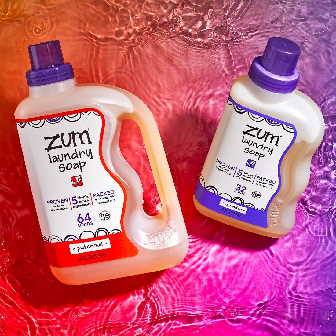 Two 64 oz and 32 oz bottles of laundry soap in the scents Patchouli and Lavender respectively. Laying at an angle on a watered surface with an orange to pink gradient background.