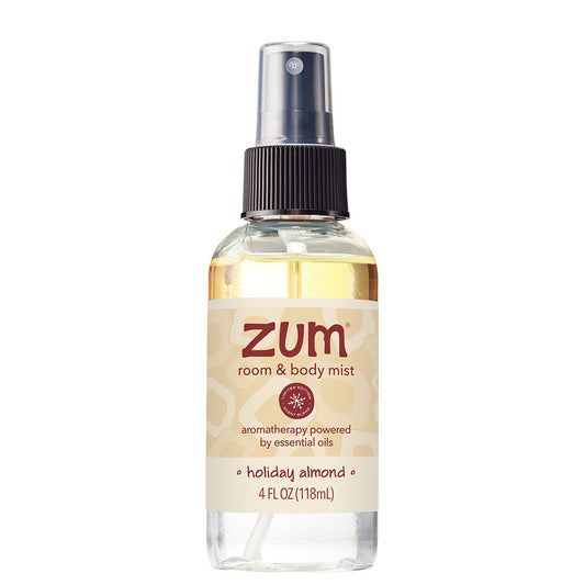 Holiday Almond Room & Body Spray in clear spray bottle with black cap and cream label.