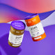 Frankincense & Myrrh and Sweet Orange Powdered Laundry Soap Containers on purple background in air.