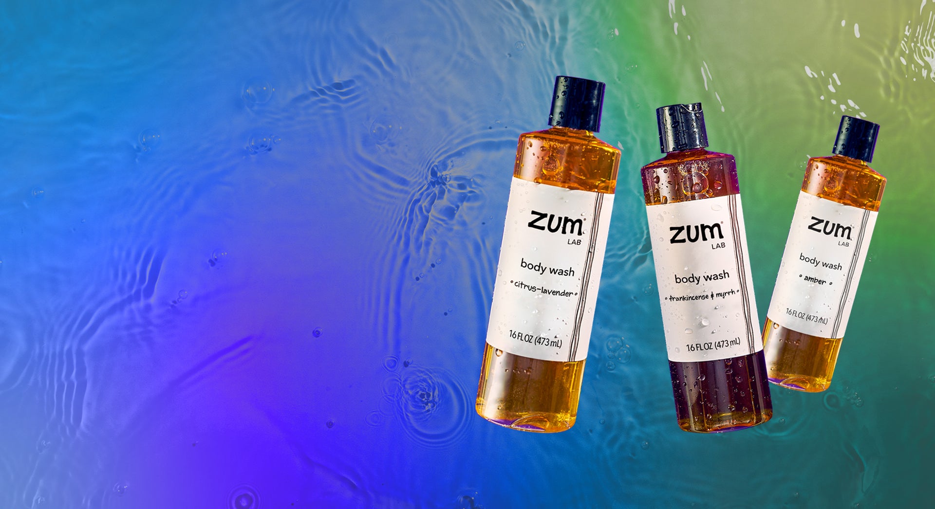 Citrus-Lavender, Frankincense & Myrrh, and Amber scented Zum Lab Body Wash bottles flying in the air. Water background with a blue, purple, green gradient overlay.