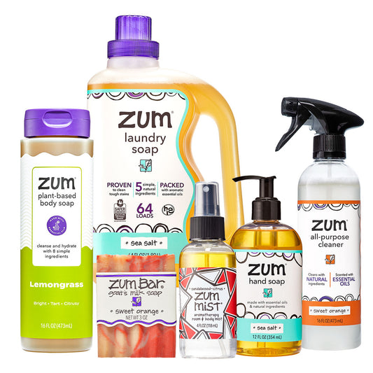 Collection of Zum cleaning products including laundry soap, body soap, hand soap, and cleaner on a white background.