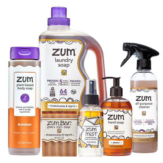 Collection of Zum cleaning products including laundry soap, body soap, hand soap, and cleaner on a white background.
