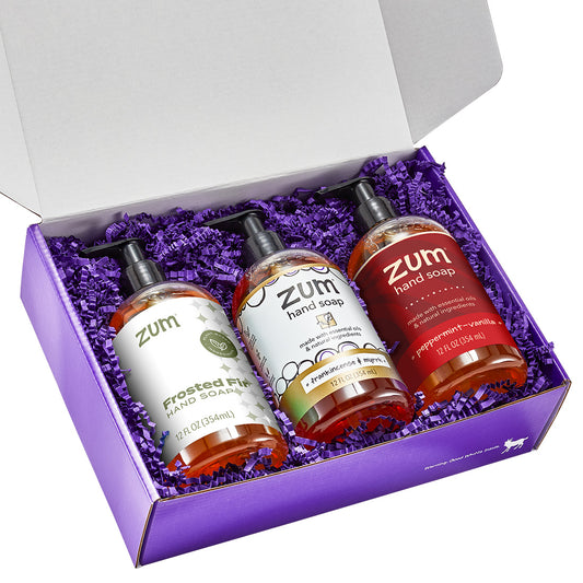Frosted Fir, Frankincense & Myrrh, and Peppermint-Vanilla Hand Soap in a purple gift box with purple crinkle.