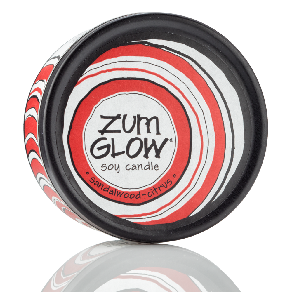 Top view 7 oz Sandalwood-Citrus Candle in a black tin with red and white label that has circular designs.