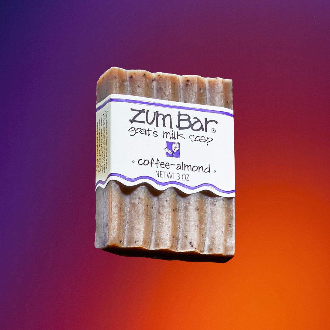 Coffee-Almond scented bar soap flying in the air with a purple to orange gradient background.