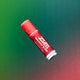 0.5 tube of lip balm in the flavor peppermint-vanilla flying in the air with a green to red gradient background.