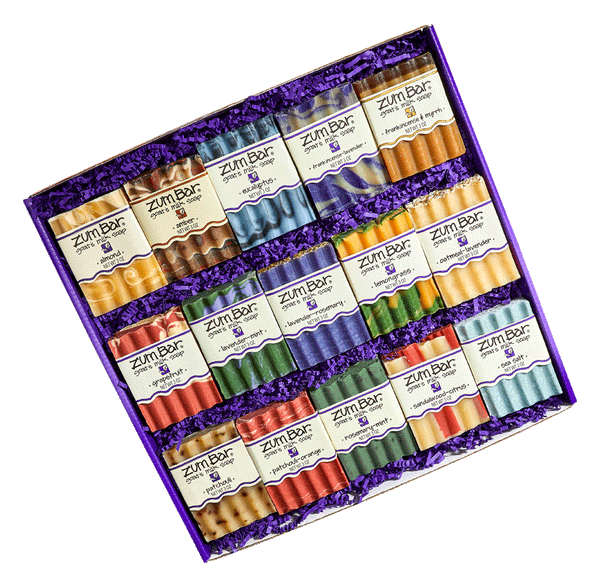 A large purple gift box filled with purple crinkle and 15 assorted bar soaps inside. Top row: Almond, Amber, Eucalyptus, Frankincense-Lavender and Frankincense & Myrrh Bar Soaps. Middle row: Grapefruit, Lavender-Mint, Lavender-Rosemary, Lemongrass, and Oatmeal-Lavender Bar Soaps. Bottom row: Patchouli, Patchouli-Orange, Rosemary-Mint, Sandalwood-Citrus, and Sea Salt.