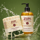 A bar of goat's milk soap and a pump bottle of Zum Hand Soap in the 'holiday almond' scent, displayed together with a water splash effect against a green background.