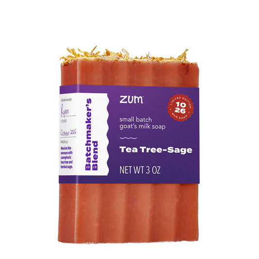 A 3 oz bar of Zum Tea Tree-Sage goat's milk soap, featuring a terracotta orange-red bar with dried botanicals on top and a purple paper label.