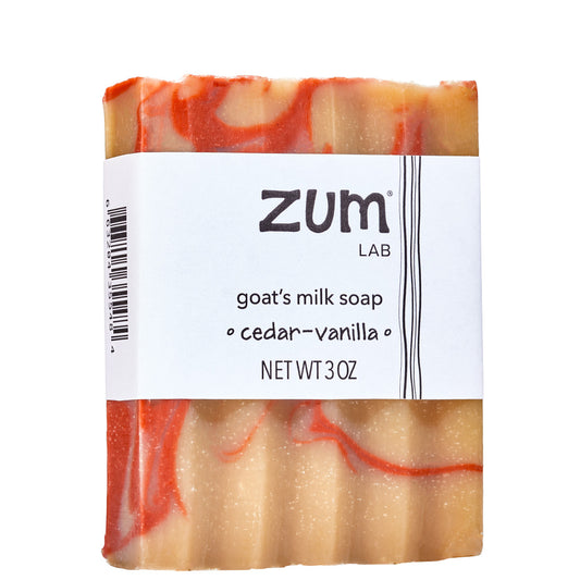 Red and yellow swirled goat's milk soap bar with white label. Scented with cedar-vanilla.