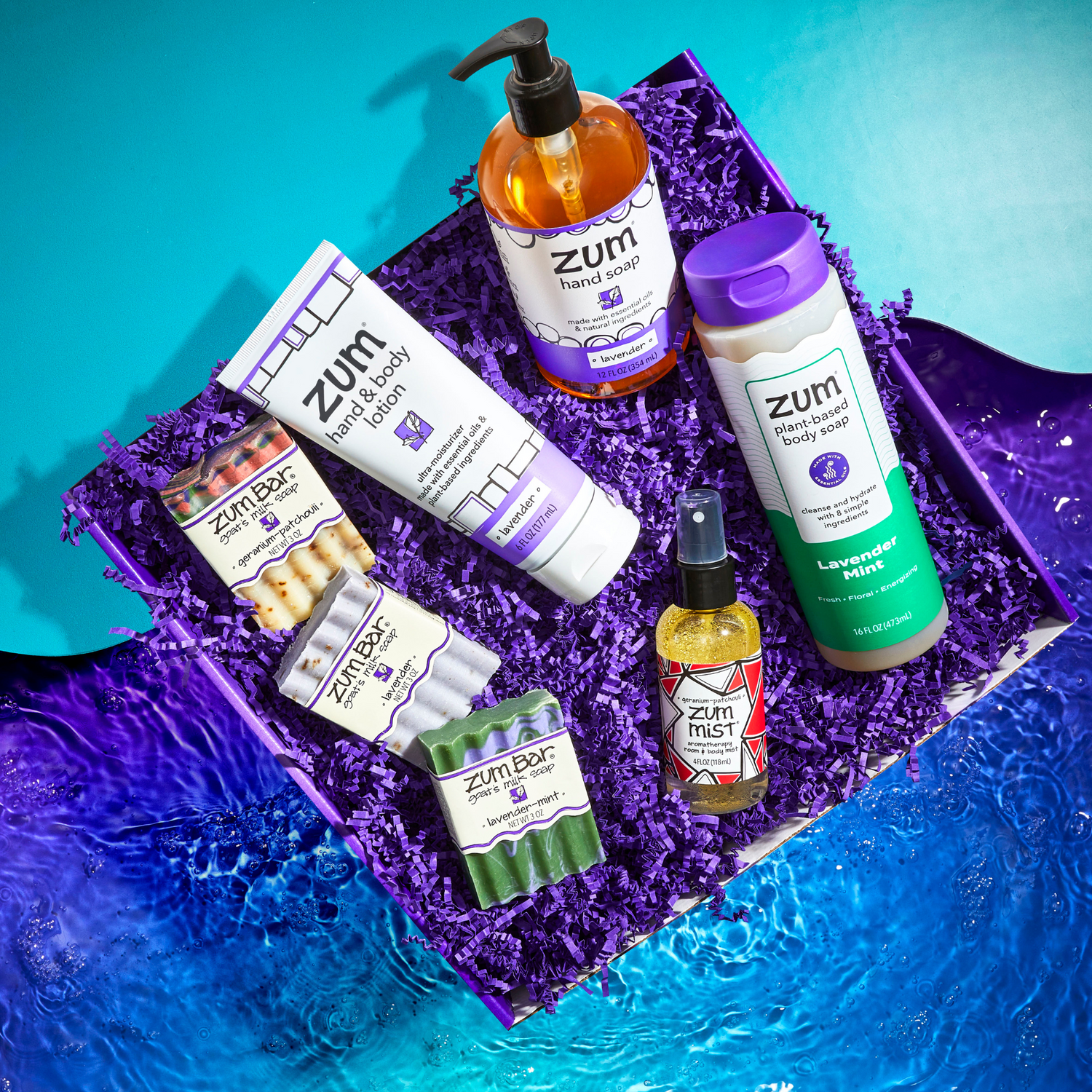 Collection of Zum body care products on a blue and purple textured background