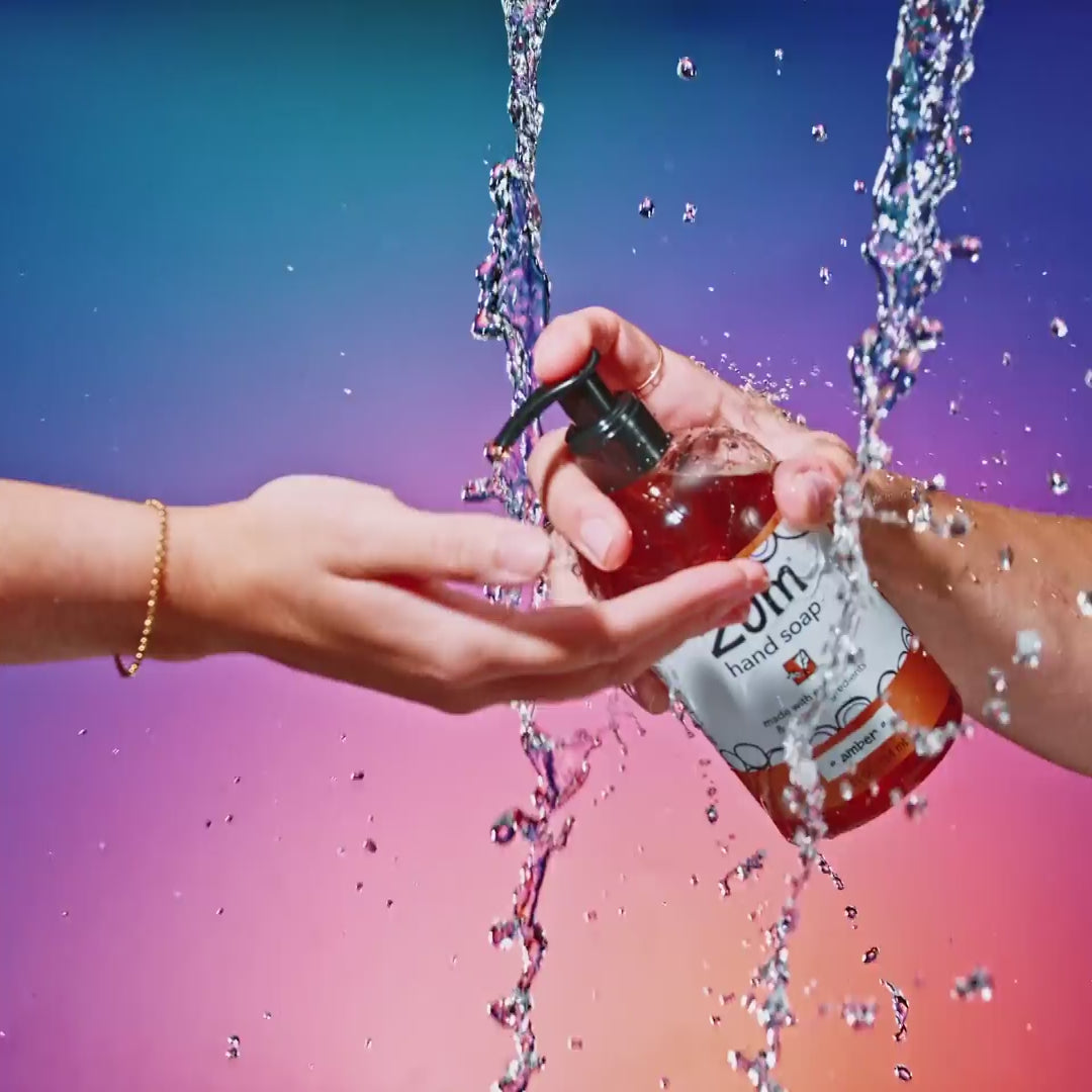 Amber Hand Soap pumping onto hand and hands lathering up.