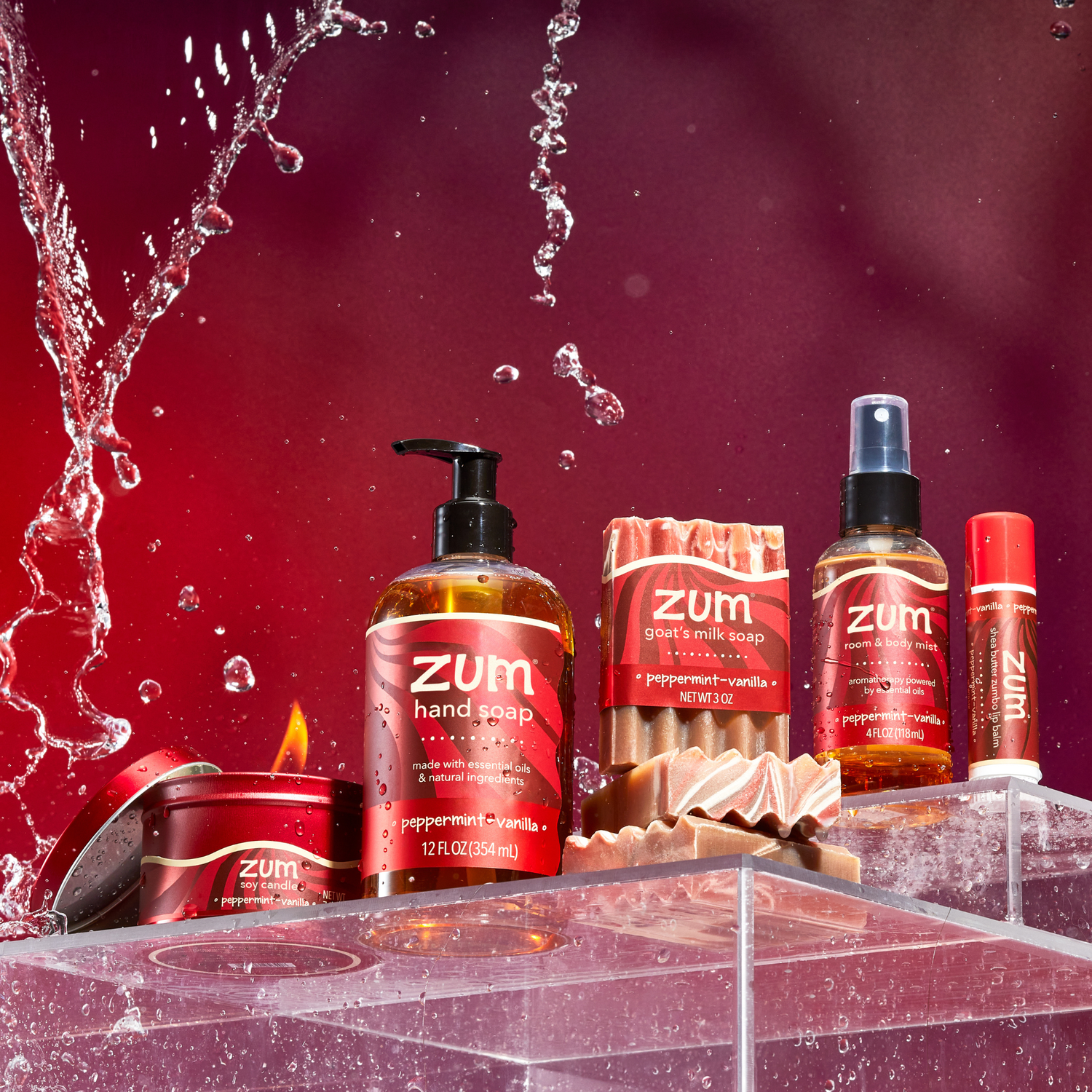 Zum products including hand soap, candles, and body wash on a red background with water splashes.
