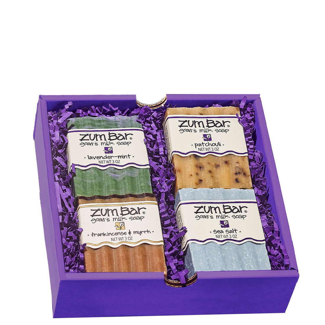 Square gift box containing 4 various Zum Bar Soaps laid in purple crinkle paper.