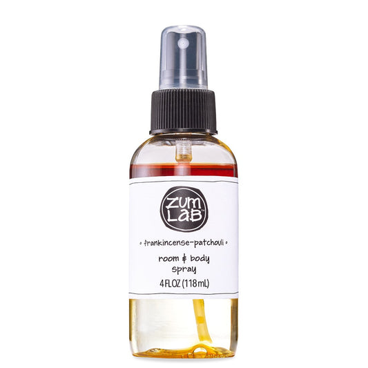 Clear round bottle with black sprayer containing frankincense and patchouli scented room and body mist