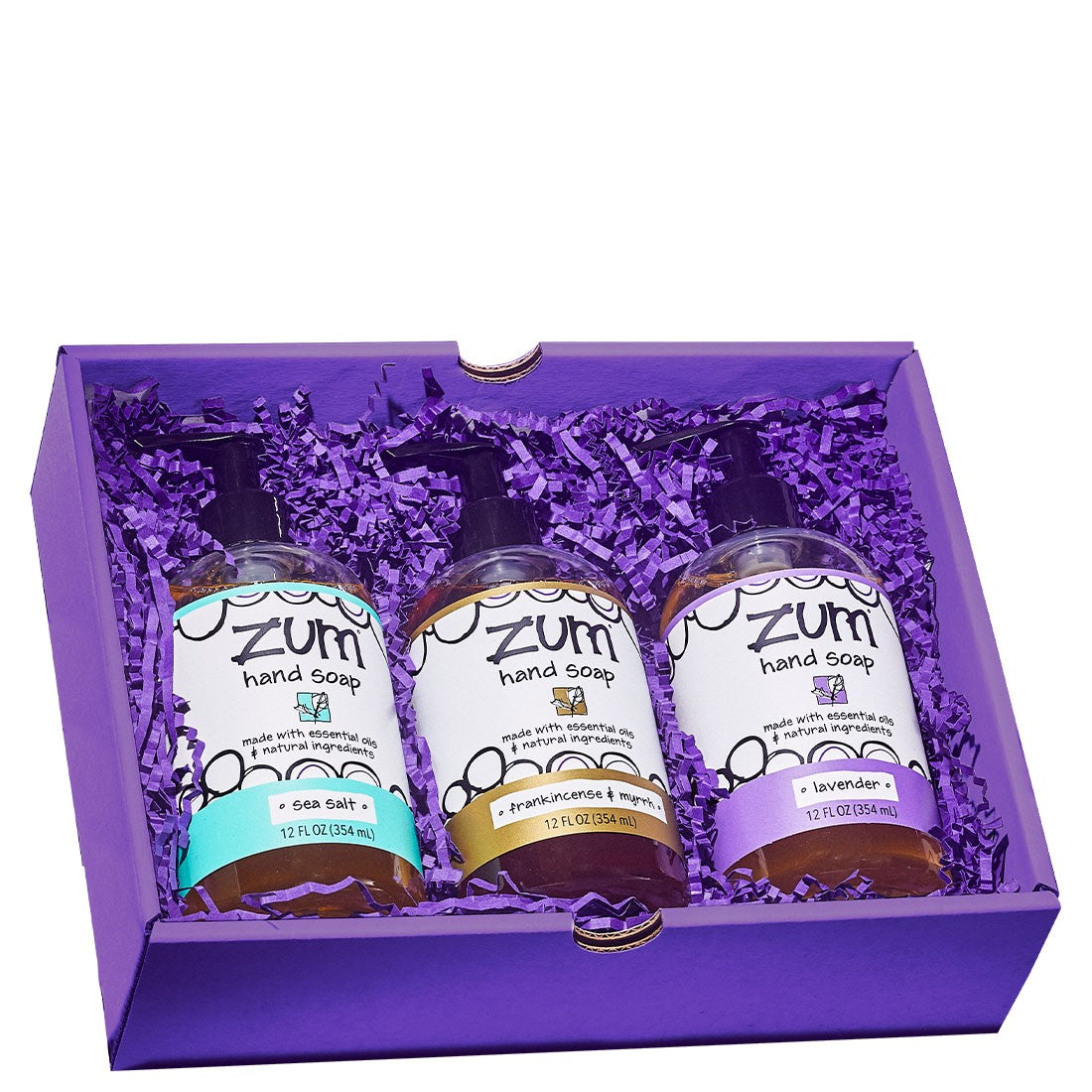 Rectangular gift box containing 3 hand soaps  with purple crinkle packing material.