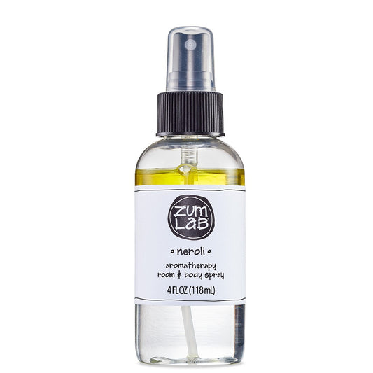 Clear round bottle with black sprayer containing Neroli scented room and body mist