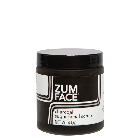 Frosted glass jar with black lid and black and white label containing charcoal infused sugar facial scrub
