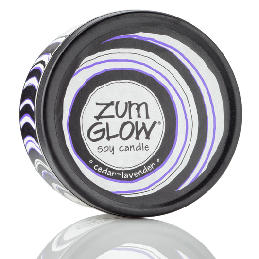 Top view 7 oz Lavender-Cedar Candle in a black tin with purple, black and white label that has circular designs.